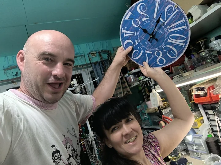 Un momento espontáneo de la vida en el taller: dos personas con un reloj de colores