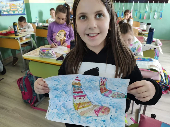 Ребёнок показывает свой рисунок в классе — из мира Жасмины и PAGANE